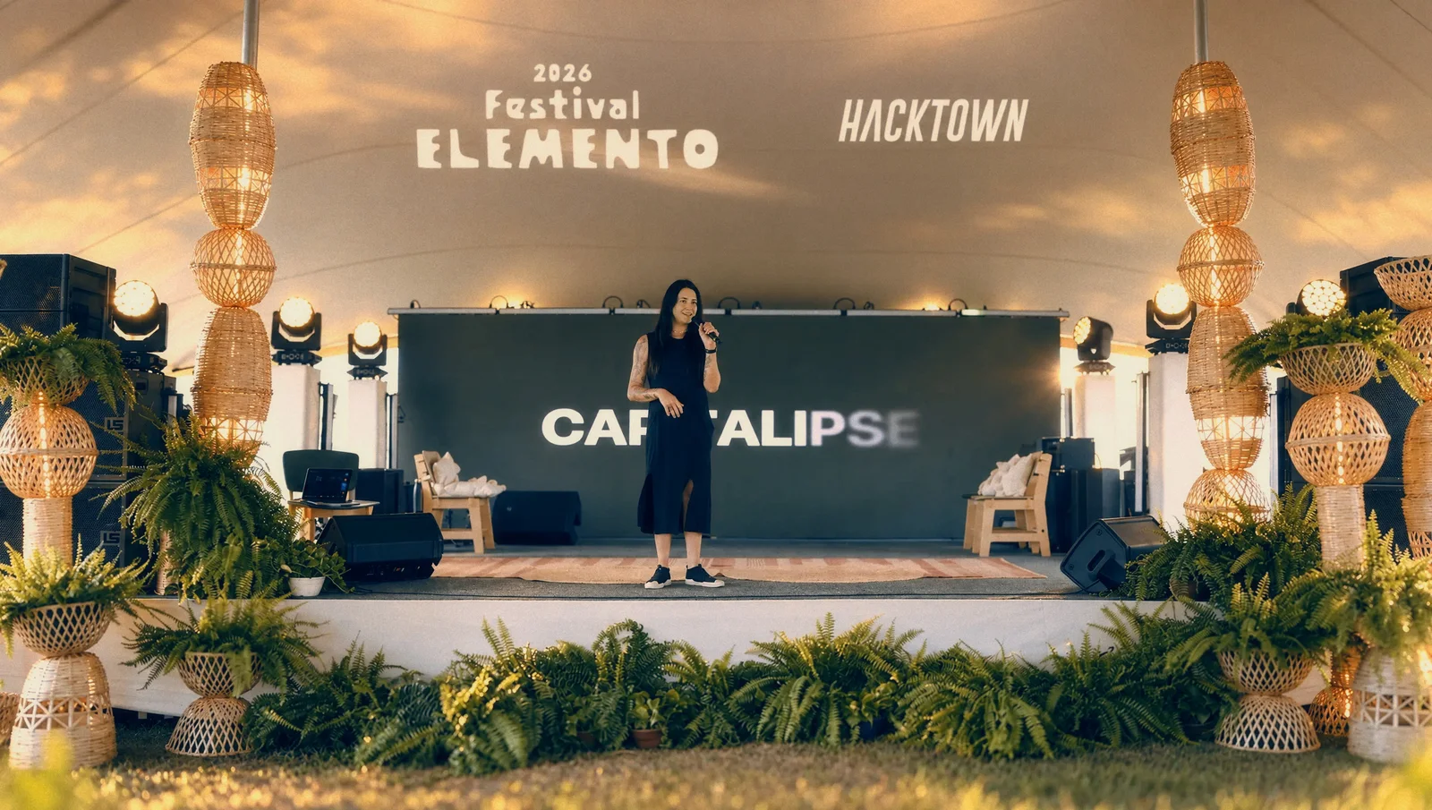 Alma no palco, com CAPITALIPSE no telão e as marcas Festival Elemento e HackTown projetadas acima